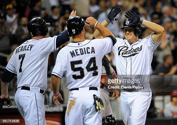 Nick Hundley of the San Diego Padres, right, is congratulated by Chase Headley and Tommy Medica after hitting a three-run homer during the sixth...