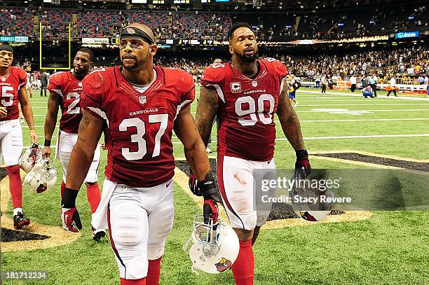 Darnell Dockett and Yeremiah Bell of the Arizona Cardinals leave the field following a game against the New Orleans Saints at the Mercedes-Benz...