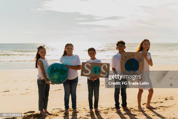 ritratto di bambini che protestano per salvare il pianeta terra sulla spiaggia - its a boy frase inglese foto e immagini stock