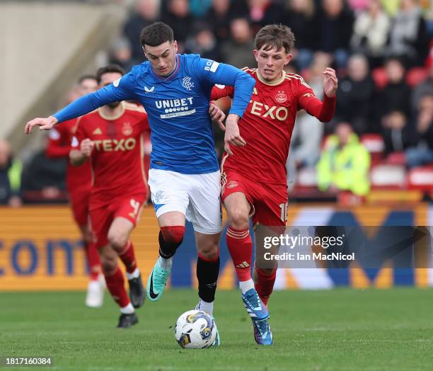 Tom Lawrence of Rangers vies with Leighton Clarkson of Aberdeen during the Cinch Scottish Premiership match between Aberdeen and Rangers FC at...