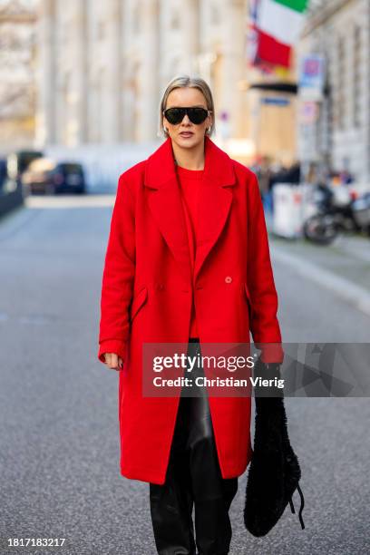 Tina Haase wears red Sézane sweater, red h&m oversize coat, YPS Black leather pants, Gucci aviator sunglasses, Proenza Schouler Black Teddy bag,...