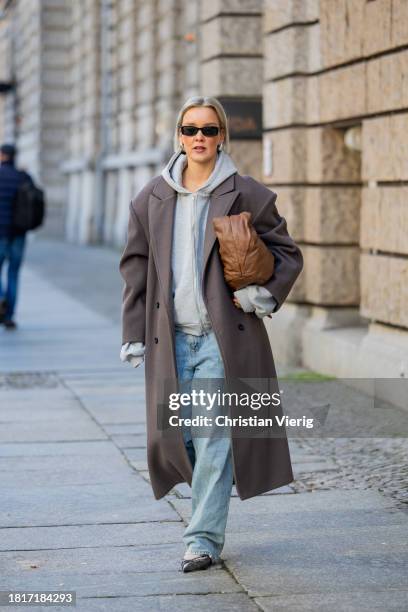 Tina Haase wears Sourceunknown taupe oversize coat, Beaumont grey zipper hoodie , Superdry baggy jeans, Borbonese brown maxi bag, Mango slingback...