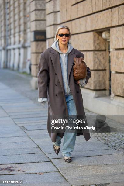 Tina Haase wears Sourceunknown taupe oversize coat, Beaumont grey zipper hoodie , Superdry baggy jeans, Borbonese brown maxi bag, Mango slingback...