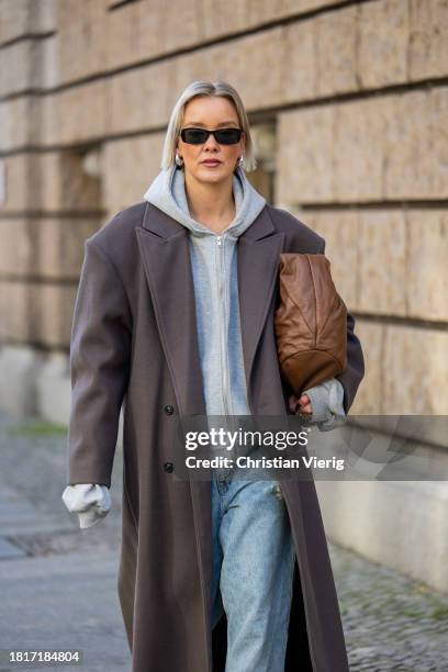 Tina Haase wears Sourceunknown taupe oversize coat, Beaumont grey zipper hoodie , Superdry baggy jeans, Borbonese brown maxi bag, Mango slingback...