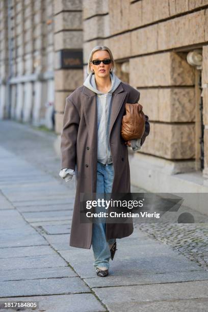 Tina Haase wears Sourceunknown taupe oversize coat, Beaumont grey zipper hoodie , Superdry baggy jeans, Borbonese brown maxi bag, Mango slingback...