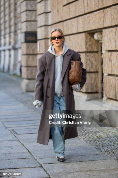 Tina Haase wears Sourceunknown taupe oversize coat, Beaumont grey zipper hoodie , Superdry baggy jeans, Borbonese brown maxi bag, Mango slingback...