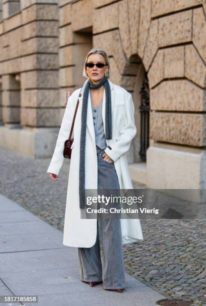 Tina Haase wears Birgitte Herskind white wool coat, H&M grey baggy jeans, Sézane burgundy Box bag, Burgundy heels, grey wool scarf on November 27,...
