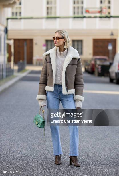 Mandy Bork wears Gant shearling jacket, Louis Vuitton boots, denim Agolde Jeans, green Chanel bag, Viky Rader Studio pullover, Vehla sunglasses on...