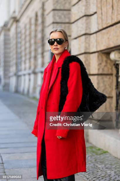Tina Haase wears red Sézane sweater, red h&m oversize coat, YPS Black leather pants, Gucci aviator sunglasses, Proenza Schouler Black Teddy bag,...