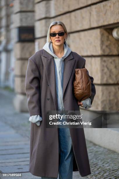 Tina Haase wears Sourceunknown taupe oversize coat, Beaumont grey zipper hoodie , Superdry baggy jeans, Borbonese brown maxi bag, Mango slingback...