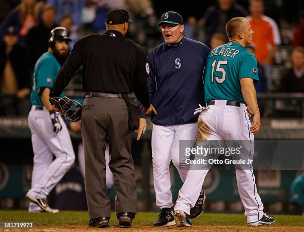 Manager Eric Wedge of the Seattle Mariners argues a call with home plate umpire Vic Carapazza after Kyle Seager was called out trying to score from...