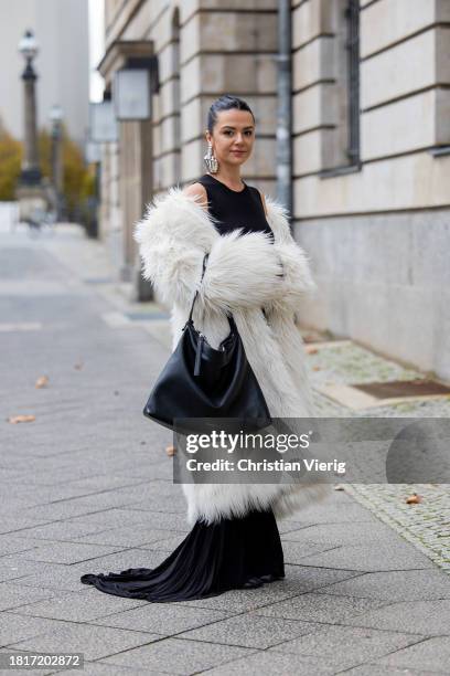Amelie Stanescu wears long mermaid evening dress by Weekday, faux fur long coat by Weekday, big oversized leather bag by Smaak Amsterdam, y project...