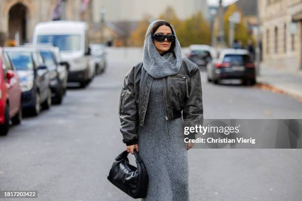 Amelie Stanescu wears grey weekday knit long dress with hoodie, acne studios distressed leather jacket, nunoo puffer bag, ottolinger sunglasses on...