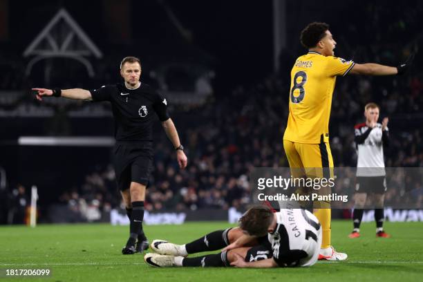 Referee Michael Salisbury points to the penalty spot, as Tom Cairney of Fulham holds his leg whilst lead on the floor, during the Premier League...