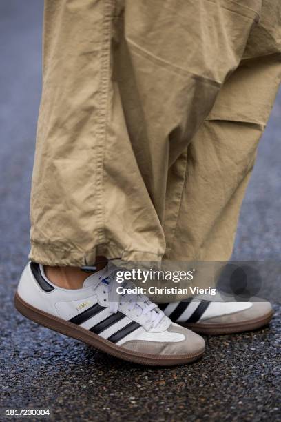 Anna Winter wears beige oversized wide leg pants the Frankie Shop, black pullover Samsoe Samsoe, brown leather jacket the Frankie Shop, sneakers...