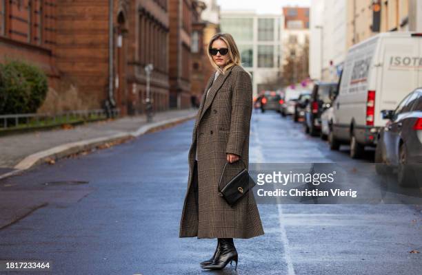 Sophie Pirrung wears oversized brown coat Filippa K, Cos boots, black Anine bing bag, Ysl sunglasses on November 27, 2023 in Berlin, Germany.