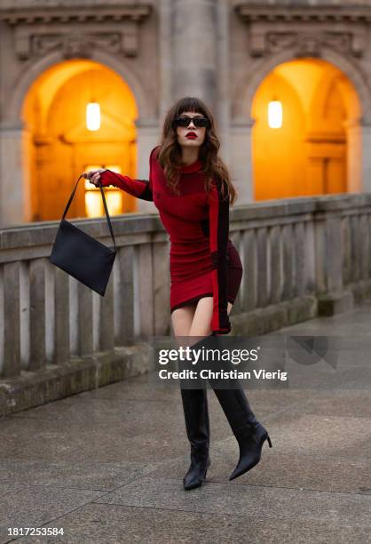 Lea Naumann wears red dress Louis Vuitton, bag Aesther Ekme, knee high black boots Cos, sunglasses Prada on November 27, 2023 in Berlin, Germany.