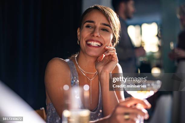 femme heureuse tenant un verre de vin lors d’une célébration du nouvel an - repas entre amis photos et images de collection