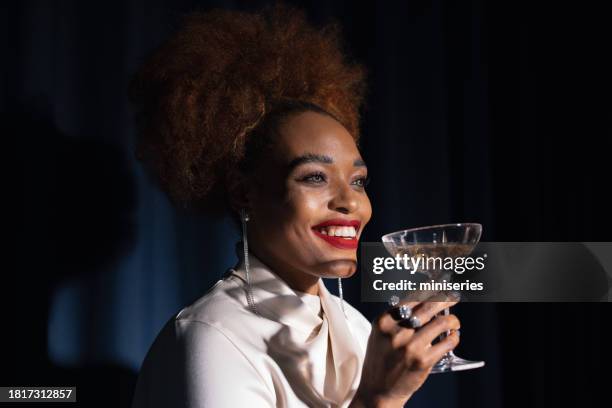 portrait of a beautiful black woman drinking a drink at the party - woman drinking stock pictures, royalty-free photos & images