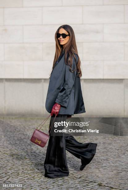 Jill Asemota wears black blazer Dodo Bar Or, T-Shirt The Attico, flared pants Maison Margiela, sunglasses Loewe, red burgundy bag Hermes, gloves on...