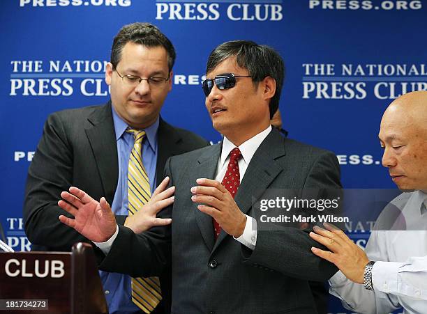 Chinese dissident Chen Guangcheng who is blind, is guided to the podium by Jared Genser of Freedom Now, before speaking at the National Press Club,...