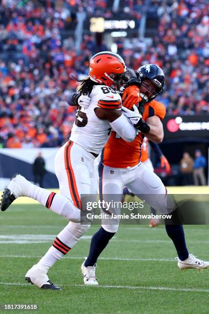 Alex Singleton of the Denver Broncos tackles David Njoku of the Cleveland Browns at Empower Field At Mile High on November 26, 2023 in Denver,...