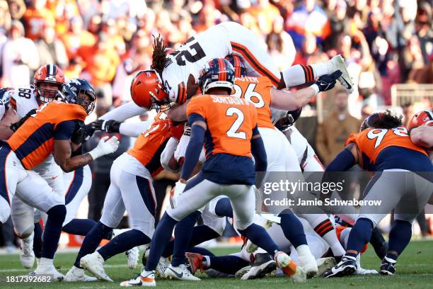 Kareem Hunt of the Cleveland Browns dives over a pile of defenders against the Denver Broncos at Empower Field At Mile High on November 26, 2023 in...