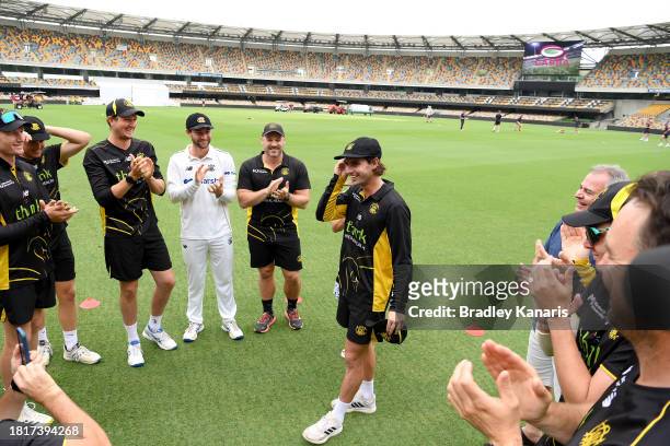 Joel Curtis of Western Australia is seen with his team mates after being presented with his cap by Cameron Bancroft of Western Australia during day...