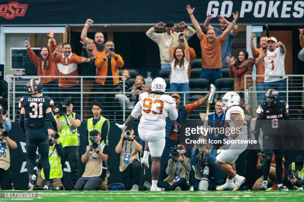 Texas Longhorns fans react to Texas Longhorns defensive lineman T'Vondre Sweat scoring a touchdown against the Oklahoma State Cowboys at ATT Stadium...