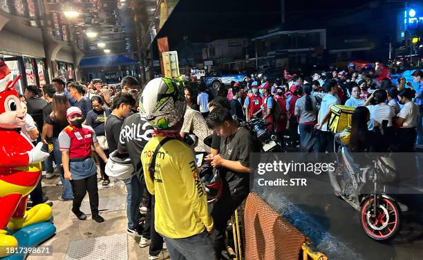 People gather along a street after evacuating from inside buildings after a 7.6 earthquake struck Butuan City, in southern island of Mindanao late...