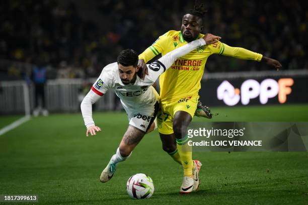 Nantes' Nigerian forward Moses Simon fights for the ball with Nice's French midfielder Morgan Sanson during the French L1 football match between FC...