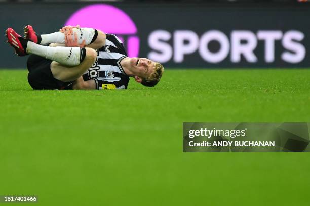 Newcastle United's English midfielder Anthony Gordon reacts after picking up an injury during the English Premier League football match between...