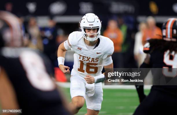 Quarterback Arch Manning of the Texas Longhorns runs behind the line against the Oklahoma State Cowboys in the second half of the Big 12 Championship...