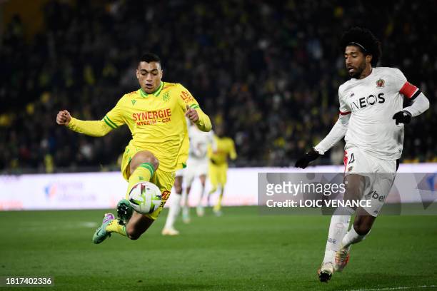 Nice's Brazilian defender Dante fights for the ball with Nantes' Egyptian forward Mostafa Mohamed during the French L1 football match between FC...