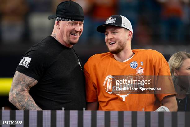 Texas Longhorns quarterback Quinn Ewers smiles with WWE legend The Undertaker after winning the Big 12 Championship game between the Texas Longhorns...