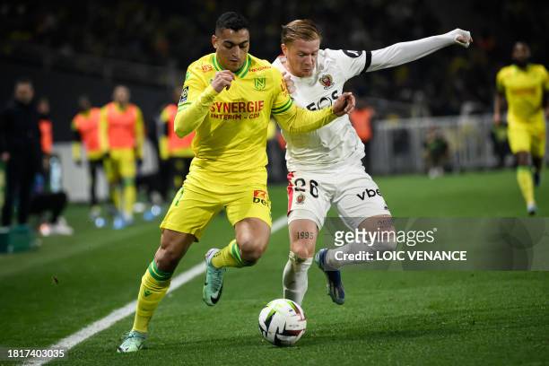 Nantes' Egyptian forward Mostafa Mohamed fights for the ball with Nice's French defender Melvin Bard during the French L1 football match between FC...