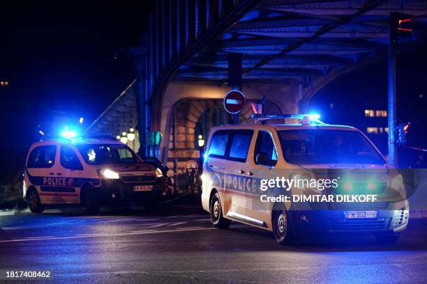 Police vehicles are seen near the scene of a stabbing in Paris on December 2, 2023. An attacker stabbed one man to death and wounded two others in...