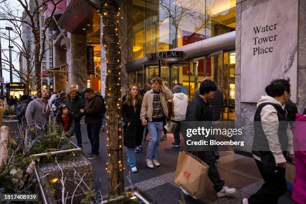Shoppers carry bags as they walk past Water Tower Place in the Magnificent Mile shopping district of Chicago, Illinois, US, on Saturday, Dec. 2,...