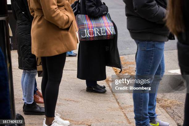 Shopper carries a J. Crew bag in the Magnificent Mile shopping district of Chicago, Illinois, US, on Saturday, Dec. 2, 2023. A burnt-out consumer,...