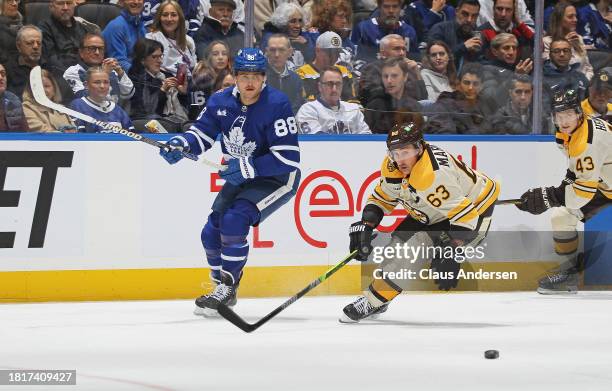 Brad Marchand of the Boston Bruins skates against William Nylander of the Toronto Maple Leafs during an NHL game at Scotiabank Arena on December 2,...