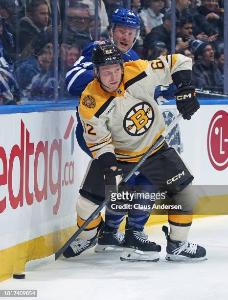 Oskar Steen of the Boston Bruins grabs a puck against Morgan Rielly of the Toronto Maple Leafs during an NHL game at Scotiabank Arena on December 2,...