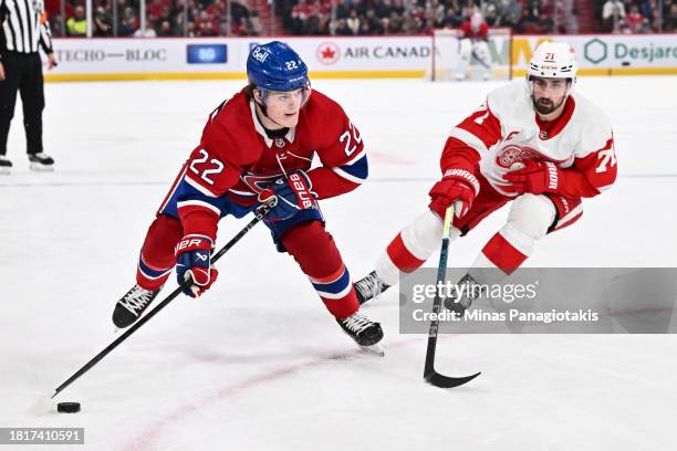 Cole Caufield of the Montreal Canadiens skates the puck against Dylan Larkin of the Detroit Red Wings during the second period at the Bell Centre on...