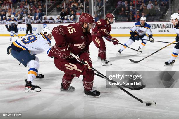 Alex Kerfoot of the Arizona Coyotes skates with the puck while being defended by Sammy Blais of the St Louis Blues during the first period of the...