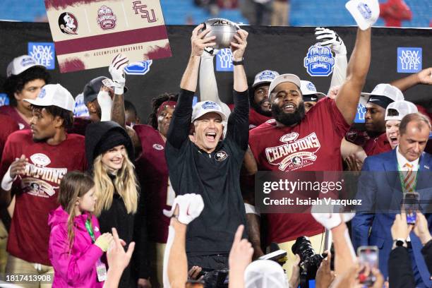 Head coach Mike Norvell of the Florida State Seminoles holds up the trophy after the Florida State Seminoles defeat the Louisville Cardinals 16-6 in...