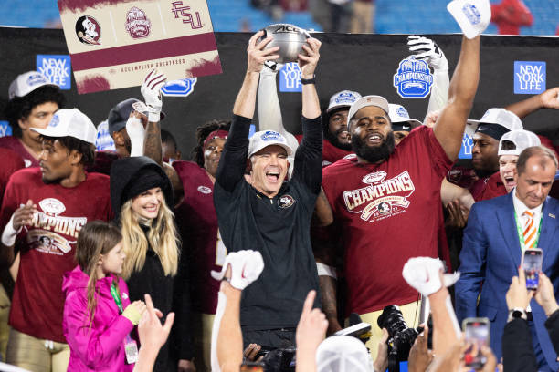 Head coach Mike Norvell of the Florida State Seminoles holds up the trophy after the Florida State Seminoles defeat the Louisville Cardinals 16-6 in...
