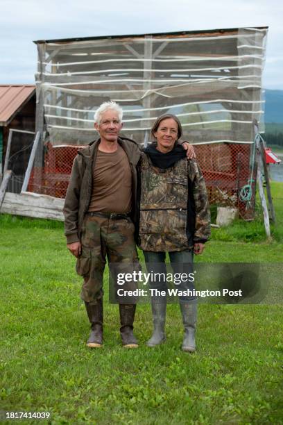 Andy Bassich, left, and his partner, Denise Becker, stand in front of their empty fish rack used for hanging salmon to dry at their home on the Yukon...