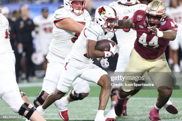 Louisville Cardinals running back Jawhar Jordan runs with the ball as Florida State Seminoles defensive lineman Joshua Farmer bears down on Jordan...