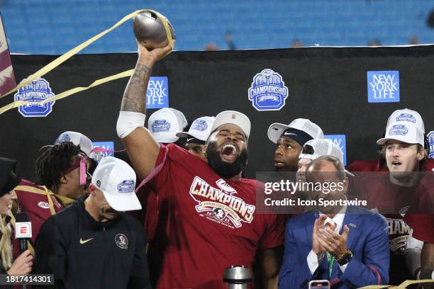 Florida State Seminoles defensive lineman Fabien Lovett Sr. Holds up the trophy in celebration during the ACC Football Championship Game between the...