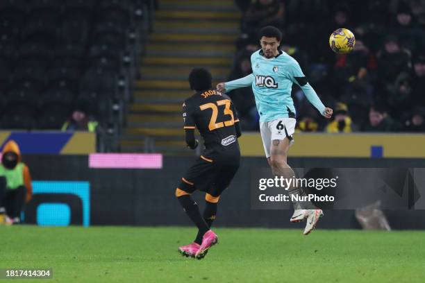Jamal Lewis of Watford is heading the ball clear from Hull City's Jaden Philogene-Bidace during the Sky Bet Championship match between Hull City and...