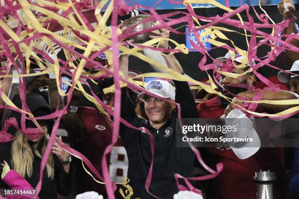 Florida State Seminoles head coach Mike Norvell holds up the trophy as the confetti flies during the ACC Football Championship Game between the...